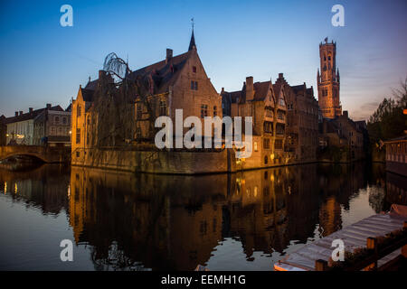 Belfort-Hallen torre campanaria dal canale in corrispondenza di Rozenhoedkaai accesa fino al crepuscolo, Bruges, Belgio Foto Stock