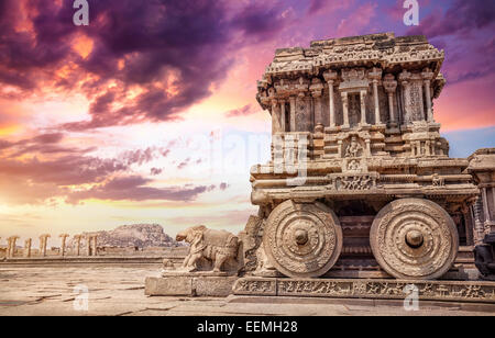 Carro di pietra nel cortile del tempio Vittala al tramonto cielo viola in Hampi, Karnataka, India Foto Stock