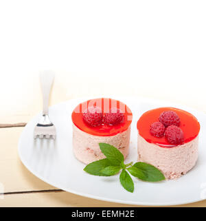 Fresche lamponi mousse torta dolce di forma rotonda con foglie di menta Foto Stock