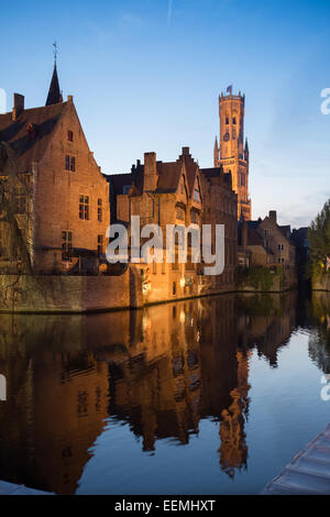 Belfort-Hallen torre campanaria dal canale in corrispondenza di Rozenhoedkaai accesa fino al crepuscolo, Bruges, Belgio Foto Stock