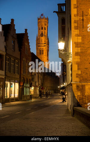 Belfort-Hallen torre campanaria da Wollestraat accesa fino al crepuscolo, Bruges, Belgio Foto Stock