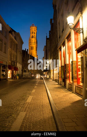 Belfort-Hallen torre campanaria da Wollestraat accesa fino al crepuscolo, Bruges, Belgio Foto Stock