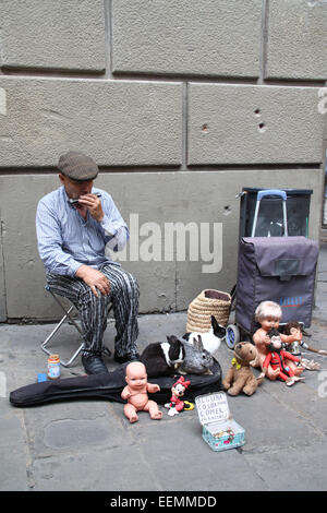 Anziani intrattenitore di strada con i conigli e i vecchi giocattoli, giocando la harmonica, vicino alla cattedrale di Barcellona, in Catalogna, Spagna Foto Stock