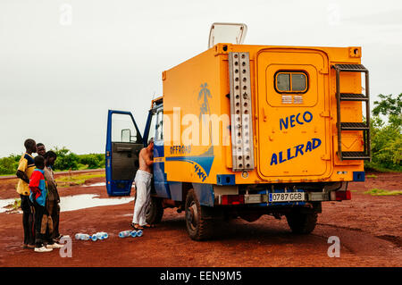 Uomo con 4x4 spedizione carrello campeggio nel bush, Mali. Foto Stock