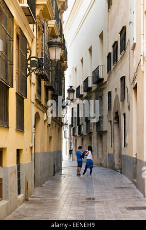 Coppia giovane studiando la mappa turistica in una stretta stradina di Valencia in Spagna Foto Stock