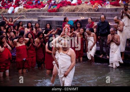 Kathmandu, Nepal. Xx gen, 2015. Un indù Nepalese devoto porta una statua dell'idolo di Madhav Narayan prima di prendere un santo tuffo nel fiume Bagmati durante il Madhav Narayan festival di Pashupatinath a Kathmandu, Nepal, 20 gennaio, 2015. Nepalese donne Indù osservare a digiunare e pregare per la dea Swasthani per la longevità dei loro mariti e la prosperità della famiglia durante i mesi di durata del festival. © Pratap Thapa/Xinhua/Alamy Live News Foto Stock