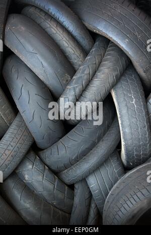 Pila di vecchi e consunti pneumatici per il riciclaggio Foto Stock