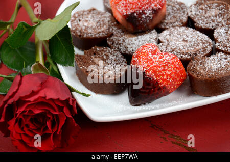 Felice il giorno di San Valentino immerso al cioccolato a forma di cuore di fragole con involtino di cioccolato rotolo svizzero a forma di cuore piastra e rosso r Foto Stock