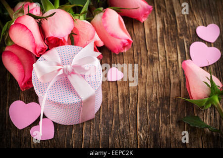 Bouquet di rose rosa e confezione regalo su sfondo di legno con spazio di copia Foto Stock