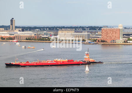 Rimorchiatore petroliera in movimento attraverso il porto di Boston, l'Aeroporto di Logan e East Boston, Boston, Massachusetts, STATI UNITI D'AMERICA Foto Stock