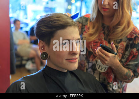 Elegante uomo con una lesione del midollo spinale in un salone di parrucchiere Foto Stock