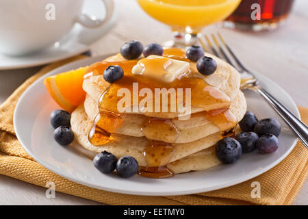 Una piastra di deliziosi pancake con mirtilli freschi e sciroppo d'acero. Foto Stock