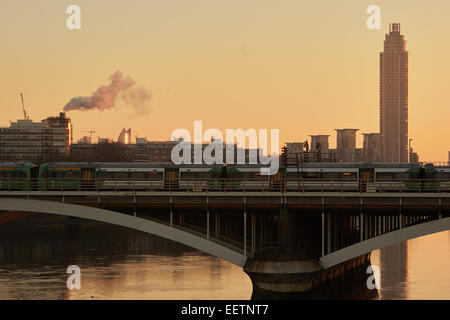 Il treno attraversa Battersea ponte ferroviario all'alba e St George Wharf Tower Londra, Inghilterra Foto Stock