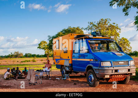 Uomo con 4x4 spedizione carrello campeggio nel bush, Mali. Foto Stock