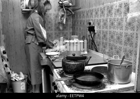 Una donna che vive in condizioni di povertà la cottura per la famiglia a San Pietroburgo, Russia degli anni novanta Foto Stock