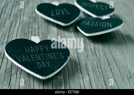 Parole di amore, rispetto e passione, e la frase felice il giorno di san valentino scritto in qualche forma di cuore lavagne, su un rustico woo Foto Stock