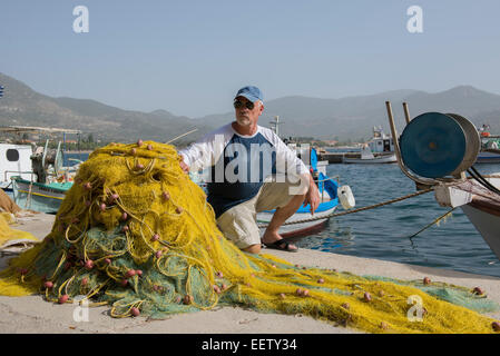 Maschio maturo su una dock con reti da pesca, Grecia Foto Stock