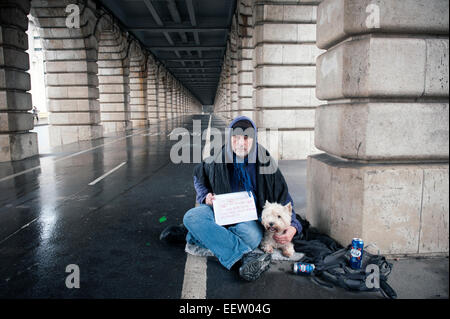 Senzatetto maschio maturo con un cane sotto un ponte Foto Stock