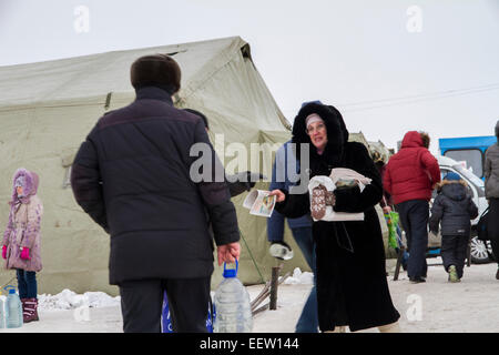 PETROPAVLOVSK, Kazakistan- 19 GENNAIO 2015: donna distribuendo volantini. Chiesa ortodossa santo giorno dell'Epifania Foto Stock