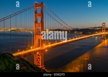 Vista notturna del Golden Gate bridge di sospensione con lo skyline della città in background, San Francisco, California, Stati Uniti d'America Foto Stock