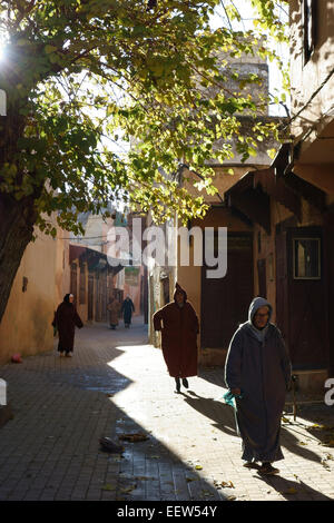 Gli uomini marocchini a piedi indossando il tradizionale djellaba incappucciato, Meknes, Marocco Foto Stock