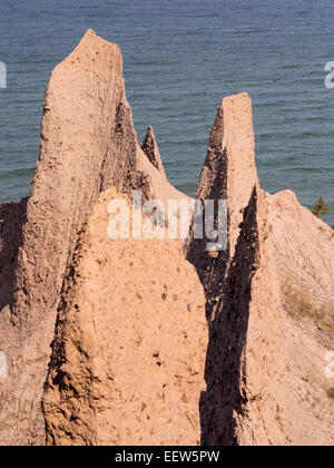 Scogliere di argilla erosione lungo la riva del lago Ontario. I camini di rosa di picco argilla formata come risultato di erosione del litorale Foto Stock