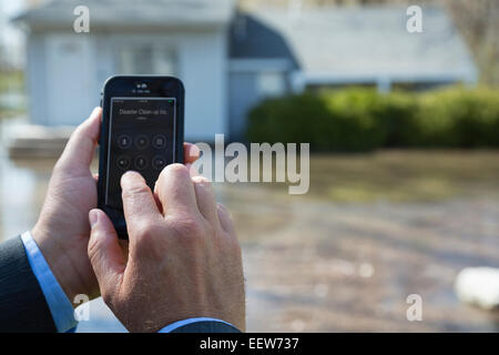 L'uomo utilizza lo smartphone durante l'alluvione Foto Stock