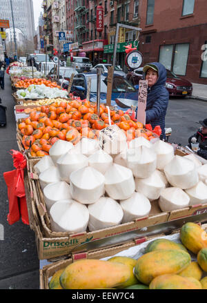 Yumy deliziosa giovani talee di noce di cocco. Una strada venditore vegetali in Chinatown Attira acquirenti con una divertente faccia ed un simpatico slogan Foto Stock