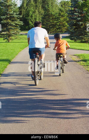 Padre e figlio al parco con le biciclette Foto Stock