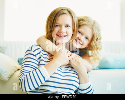 Affettuosa giovane ragazza abbracciando la madre Foto Stock