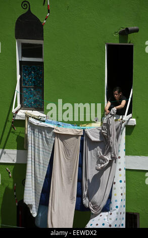 (150122) -- Valparaiso, 22 gennaio 2015 (Xinhua) -- Immagine presa il 20 gennaio 2015, mostra una donna vestiti appesi dalla finestra della sua casa di Concepcion Hill nella città di Valparaiso, Cile. A causa della sua ricchezza architettonica sviluppato nel XIX secolo, Valparaiso è stata dichiarata Patrimonio Mondiale nel 2013 dalle Nazioni Unite per l'Educazione, la scienza e la Cultura (UNESCO). Con le sue antiche case, edifici, chiese, vicoli, colline, gole, scale e ciottoli, Valparaiso era una singolare testimonianza dell'inizio dell'era industriale del XIX secolo quando la città divenne il principale po Foto Stock