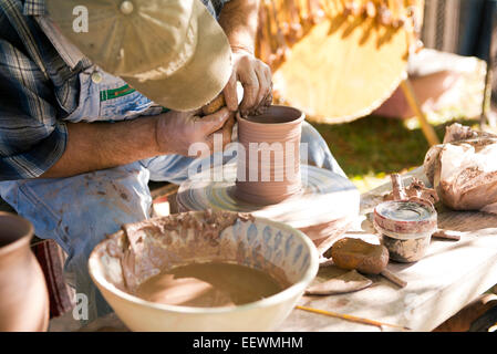 A North Carolina Potter "gettando' argilla su una ruota in ceramica Foto Stock