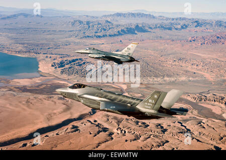 US Air Force F-35un fulmine II Stealth Fighter Aircraft e F-16 Fighting Falcon fighter approcciare il Lake Mead National Recreation Area in itinerario alla Nellis Air Force Base di Gennaio 15, 2015 in Nevada. La F-35 sarà utilizzato per lo sviluppo di tattiche e di creare il curriculum per la prima F-35 armi corso istruttori. Foto Stock