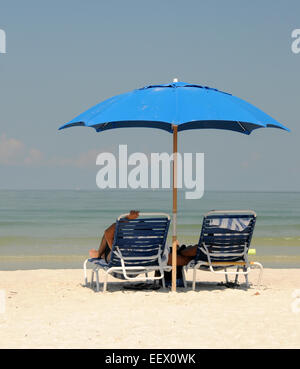 Matura in appoggio sulla sdraio in spiaggia e di sabbia bianca Foto Stock