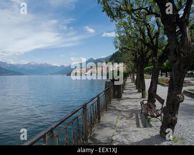 L'affascinante passeggiata sul lago di Bellagio sul Lago di Como in Italia conduce alla città e con uno sfondo montano Foto Stock