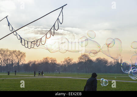 Hyde Park, London, Regno Unito. Il 22 gennaio 2015. Richard Shaw crea bolle di sapone come il sole tramonta in un freddo giorno di Hyde Park, Londra. Credito: Matteo Chattle/Alamy Live News Foto Stock