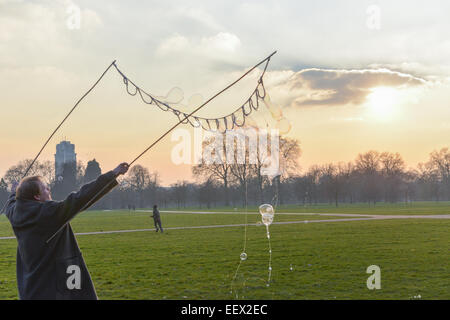 Hyde Park, London, Regno Unito. Il 22 gennaio 2015. Richard Shaw crea bolle di sapone come il sole tramonta in un freddo giorno di Hyde Park, Londra. Credito: Matteo Chattle/Alamy Live News Foto Stock