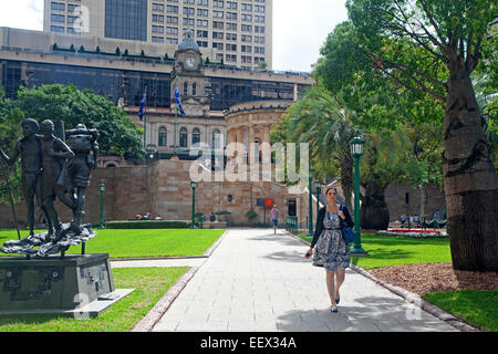La stazione ferroviaria centrale e la donna a piedi attraverso il parco della città nel centro di Brisbane, la capitale del Queensland, Australia Foto Stock