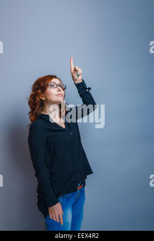 Brunette donna trenta anni mostra pollice in alto su sfondo blu Foto Stock