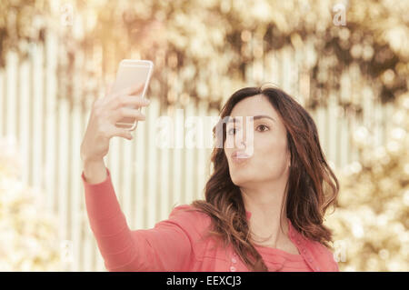 La tecnologia dello stile di vita e il concetto di rilassamento della bella giovane donna prendendo selfie con lo smartphone Foto Stock