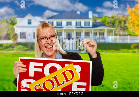 Excited donna tenendo le chiavi di casa e venduto beni immobili segno davanti di Nizza nuova casa. Foto Stock