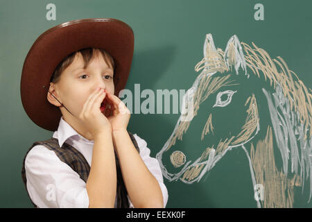 Un piccolo ragazzo giocando in cowboy Foto Stock