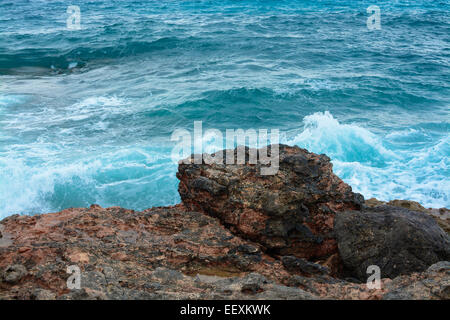 Rosso terra roccia calcarea contrastante con mediterraneo blu azzurro Oceano. Foto Stock