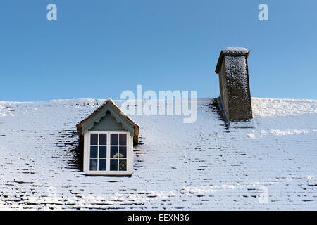 Tetto del cottage coperto di neve. Riponi sul Wold, Cotswolds, Gloucestershire, Inghilterra Foto Stock