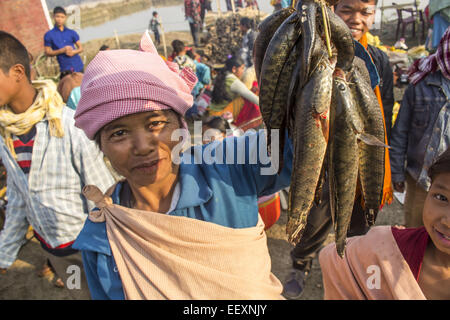 Morigaon, Assam, India. 23 gen 2015. Una donna tribale dalla comunità Tiwa visto la visualizzazione di pesce per uno scambio tramite sistema di baratto al festival Joonbeel Morigaon nel distretto di nord-est Assam il 23 gennaio 2014. Centinaia di comunità tribali come Tiwa, Karbi, Khasi e Jaintia dalle vicine colline scendono in grandi numeri per prendere parte al festival scambiare merci attraverso il baratto piuttosto che denaro. Attività di pesca della Comunità è trattenuta anche durante questo festival. Il punto significativo di questo festival è il suo tema di armonia e fratellanza tra varie tribù e comunità. Durante Foto Stock