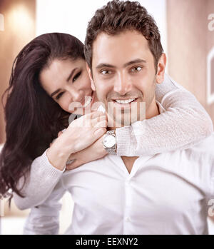 Ritratto di carino allegro la famiglia a casa, uomo bello portare sul retro la sua bella moglie, felice il giorno di San Valentino, il concetto di amore Foto Stock