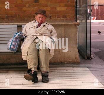 OAP vecchiaia titolare di pensione o di rendita, anziano uomo dorme addormentato sulla panchina alla stazione di Liverpool Street London Foto Stock