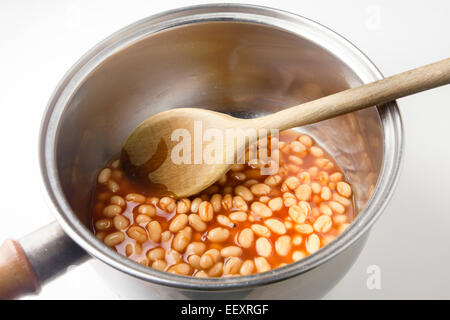 Pentola di fagioli per la cottura in un forno a gas di cottura con il  cucchiaio di legno Foto stock - Alamy