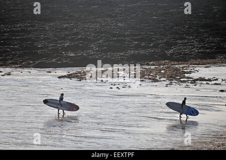 Due surfisti in prima serata su Gyllyngvase Beach, Falmouth, Regno Unito Foto Stock