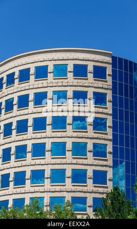 Blu di Windows in edificio curvo che riflette il Cielo e nubi Foto Stock